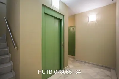 a green elevator door in a hallway with stairs at Palau de la música 5 in Barcelona