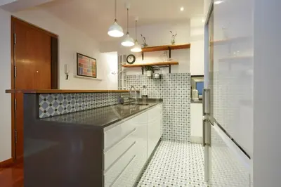 a kitchen with white cabinets and a black counter top at Nice apartment in Les Corts in Barcelona