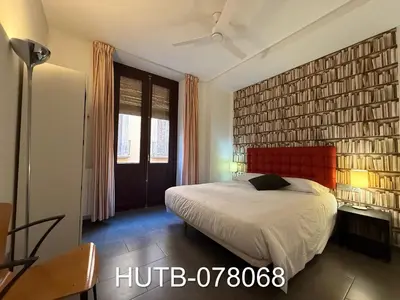 a bedroom with a bed and a large brick wall at Palau de la música 8 in Barcelona