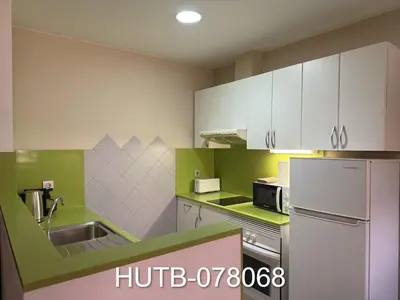 a kitchen with green and white cabinets and a refrigerator at Palau de la música 8 in Barcelona
