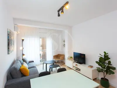 a living room with a couch and a tv at Agradable y luminoso apartamento ideal para 5 in Barcelona