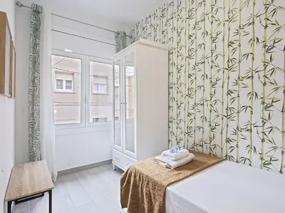 a bedroom with a bed and a shower and a window at Alcam Baro in Barcelona