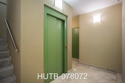 a green elevator door in a hallway with stairs at Palau de la música 12 in Barcelona
