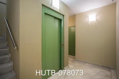 a green elevator door in a hallway with stairs at Palau de la música 13 in Barcelona