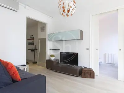 a living room with a couch and a chandelier at Apartamento Luminoso cerca de Montjuïc in Barcelona