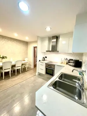 a kitchen with a sink and a table with chairs at Spacious Penthouse with big private terrace & view in Barcelona