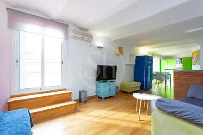 a living room with a couch and a tv at Apartamento con Terraza en Eixample in Barcelona