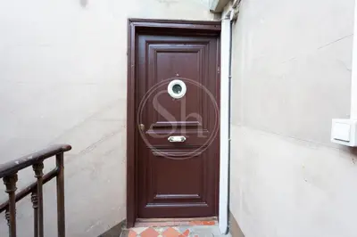 a brown door with a security camera on it at Apartamento con Terraza en Eixample in Barcelona