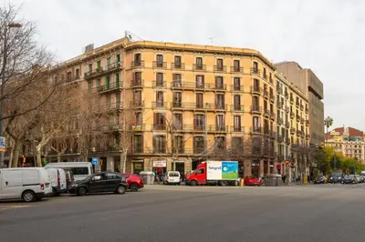 a large yellow building with cars parked in front of it at Apartamento con Terraza en Eixample in Barcelona