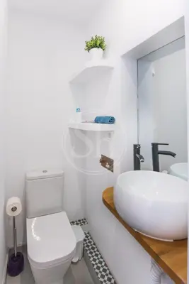 a bathroom with a white toilet and a sink at Acogedor apartamento en el Eixample in Barcelona