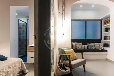 a bedroom with a bed and a chair and a couch at Acogedor apartamento en el Eixample in Barcelona