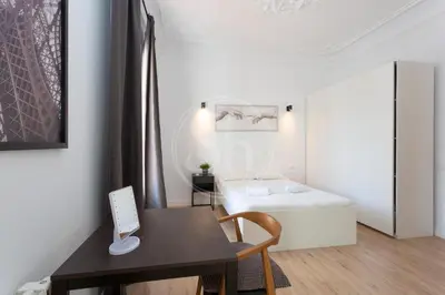 a small room with a bed and a desk with a computer at Céntrico apartamento familiar in Barcelona