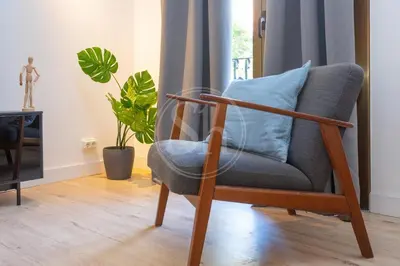 a chair with a blue pillow in a living room at Céntrico apartamento familiar in Barcelona