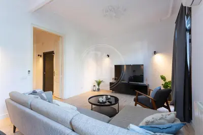 a living room with a couch and a tv at Céntrico apartamento familiar in Barcelona