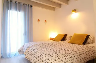 a bedroom with a bed with yellow pillows and a window at Mediterrani Vacaciones perfectas y vistas al mar in Sitges