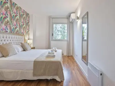 a white bedroom with a large bed and a window at Alcam Espronceda in Barcelona