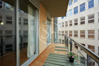 a balcony of a building with a bench and flowers at Bonito alojamiento cerca de Estación de Sants in Barcelona