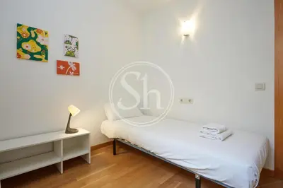 a bedroom with a bed and a desk with a lamp at Bonito alojamiento cerca de Estación de Sants in Barcelona