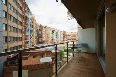 a balcony with a table and chairs and buildings at Bonito alojamiento cerca de Estación de Sants in Barcelona