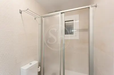 a glass shower stall in a bathroom with a toilet at Apartamento Familiar junto a Hospital Clinic in Barcelona
