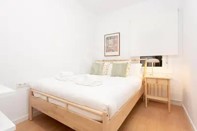 a bedroom with a large bed with white sheets at Apartamento Familiar junto a Hospital Clinic in Barcelona