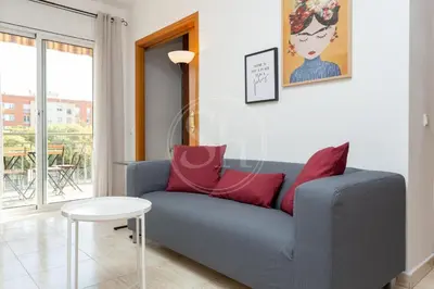 a living room with a blue couch and red pillows at Apartamento para 3 con balcón in Barcelona