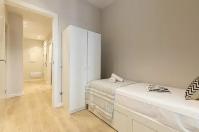 a white bedroom with a bed and a closet at Ola Living Gracia in Barcelona