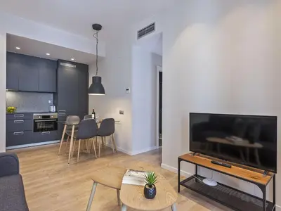 a living room with a large flat screen tv at Ola Living Gracia in Barcelona