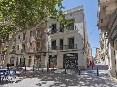 a building on a street with tables and chairs at Ola Living Gracia in Barcelona