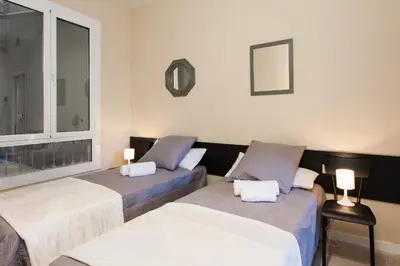 a hallway with white walls and a table and a chair at Key Plaza Cataluña Bliss in Barcelona
