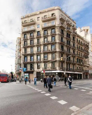 a bedroom with two beds and a chair at Key Plaza Cataluña Bliss in Barcelona