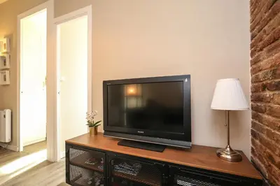 a flat screen tv sitting on top of a wooden table at The Sants's balcony in Barcelona