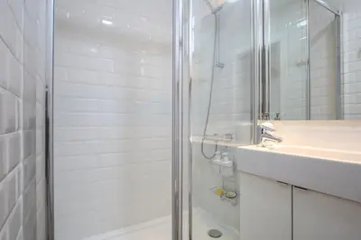a white bathroom with a shower and a sink at The Sants's balcony in Barcelona