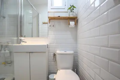 a white bathroom with a toilet and a sink at The Sants's balcony in Barcelona