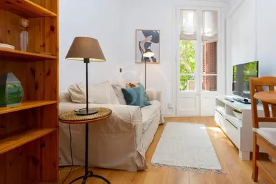 a living room with a white couch and a table at Cozy apartment near Sagrada Familia in Barcelona