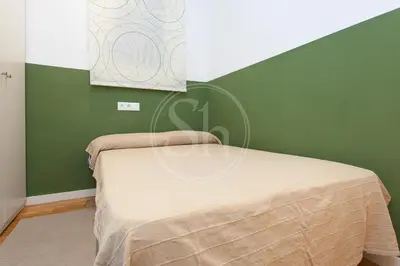 a bed in a room with a green wall at Bonito apartamento en La Rambla del Poblenou in Barcelona