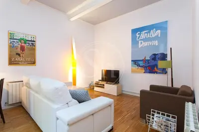 a living room with a white couch and a tv at Bonito apartamento en La Rambla del Poblenou in Barcelona
