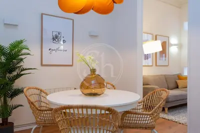 a living room with a table with chairs and a vase on it at Cómodo piso en Eixample in Barcelona