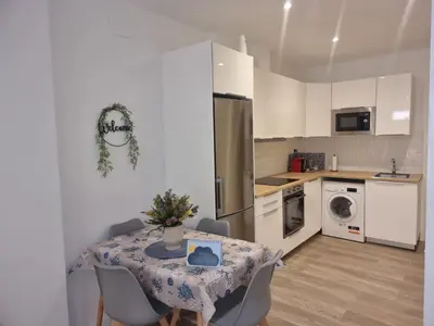 a kitchen with a table and a refrigerator at Piso céntrico a estrenar in Vilanova i la Geltrú