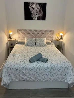 a living room with two beds and a kitchen at Piso céntrico a estrenar in Vilanova i la Geltrú