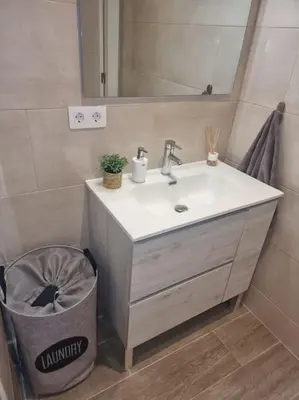 a bathroom with a sink and a trash can at Piso céntrico a estrenar in Vilanova i la Geltrú