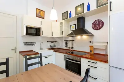 a kitchen with white cabinets and a wooden table at Apartamento en Sagrada Familia E in Barcelona