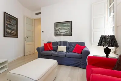 a living room with a blue couch and red chairs at Apartamento en Sagrada Familia E in Barcelona