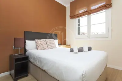a bedroom with a white bed and a window at Apartamento en Sagrada Familia 2 in Barcelona