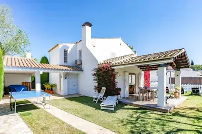 a white house with a table and a gazebo at Villa Romady in Sant Pere de Ribes