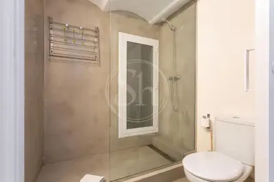 a white bedroom with a bed and a mirror at Apartamento en Villaroel 2 in Barcelona