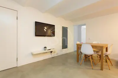 a kitchen and living room with a table and a couch at Apartamento en Villaroel 2 in Barcelona