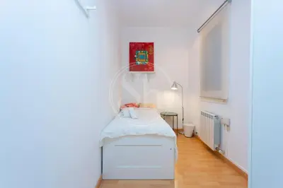 a plant sitting on a table next to a bed at Apartamento familiar en AvDiagonal in Barcelona