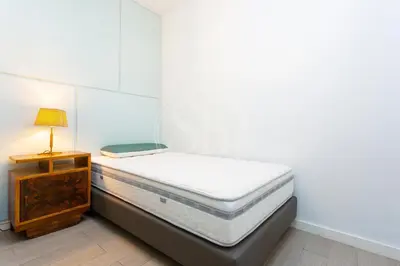 a small bedroom with a bed and a night stand at Precioso apartamento en Les Corts in Barcelona