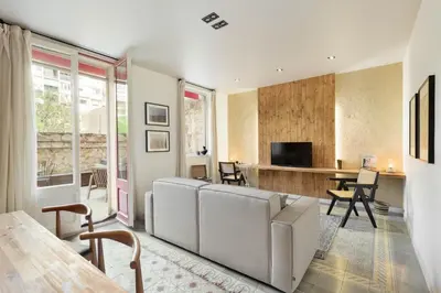 a patio with chairs and a stone fireplace at Jaiz - 2 bedrooms and terrace in Eixample Esquerra in Barcelona